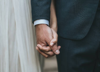 The bride and groom hand in hand.