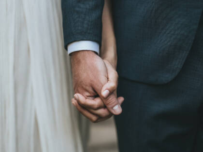 The bride and groom hand in hand.