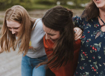 Three women walking and laughing.