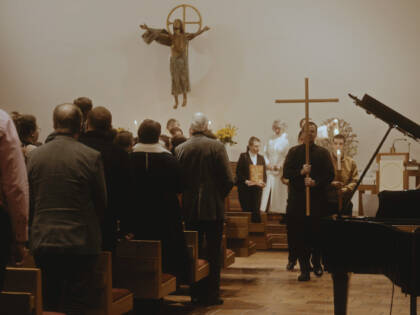 A person is carrying a cross in a procession in church.