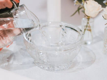 Someone is pouring water in to the baptism bowl.
