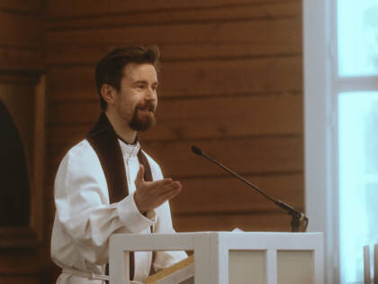 A pastor is speaking from the pulpit.