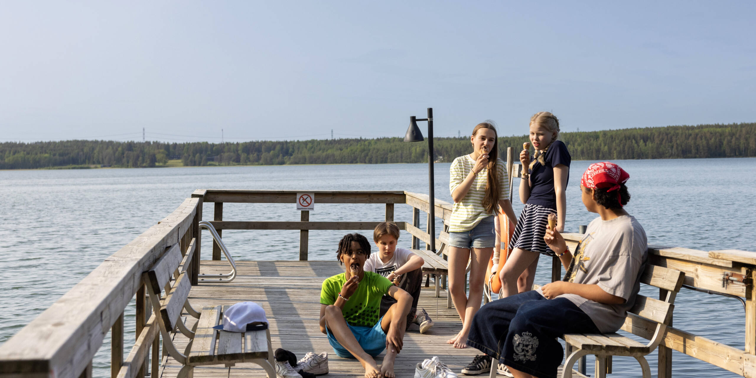Young people eating ice cream on the pier.
