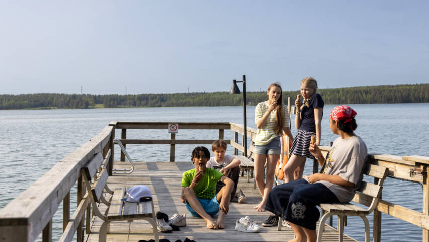Young people eating ice cream on the pier.