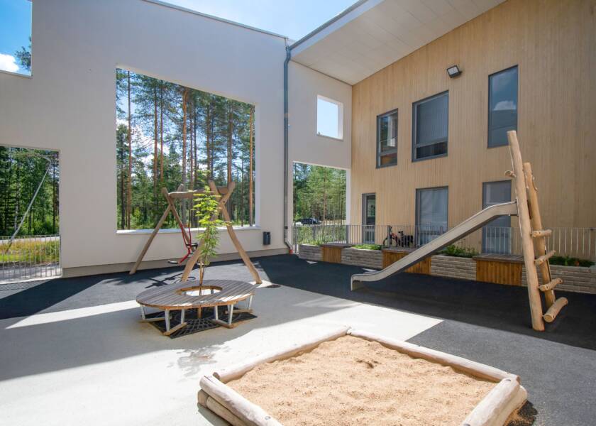 The building’s inner courtyard, with a sandpit. Trees all around.