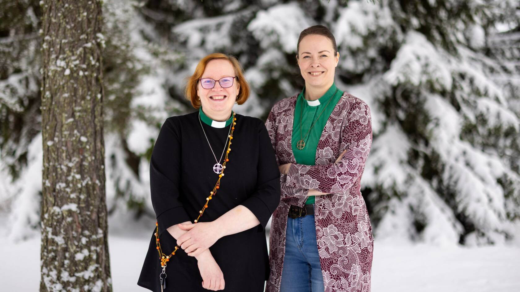 Kaksi naista seisoo puun vieressä talvella.