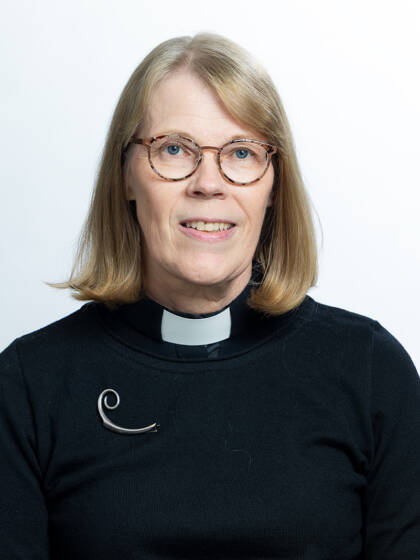 A person dressed in black. Clerical collar.