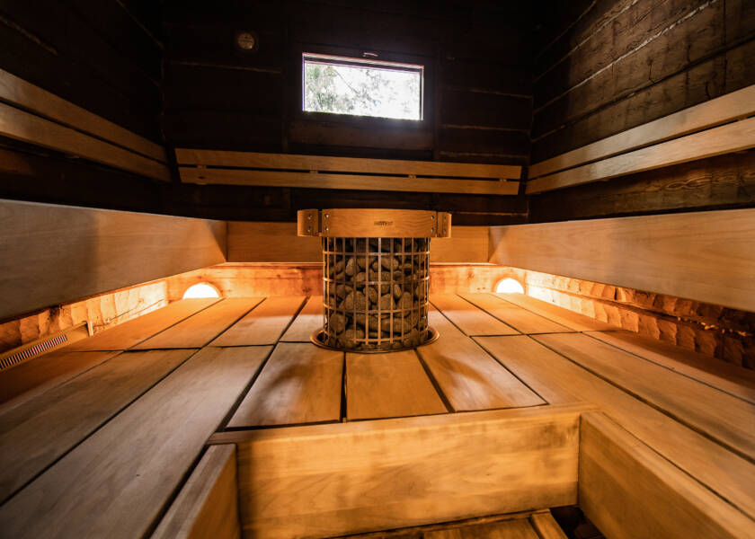 Sauna jossa puiset lauteet ja pyöreä kiuas.