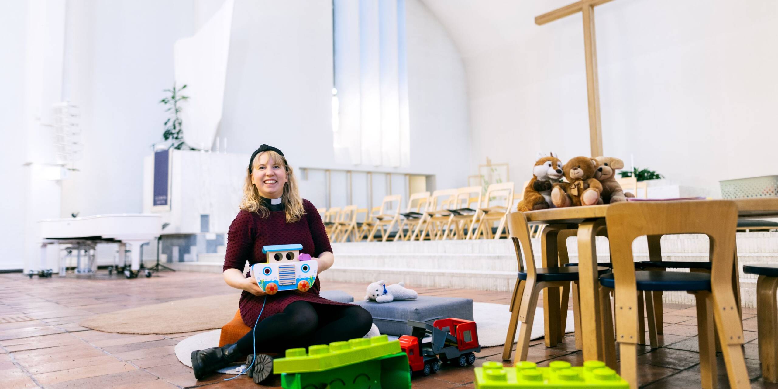 Pappi istuu Lakeuden Ristin kirkon leikkipaikan lattialla.