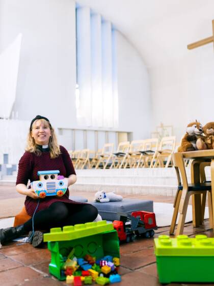 Pappi istuu Lakeuden Ristin kirkon leikkipaikan lattialla.