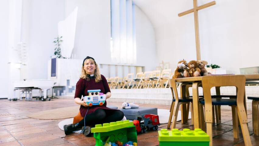 Pappi istuu Lakeuden Ristin kirkon leikkipaikan lattialla.