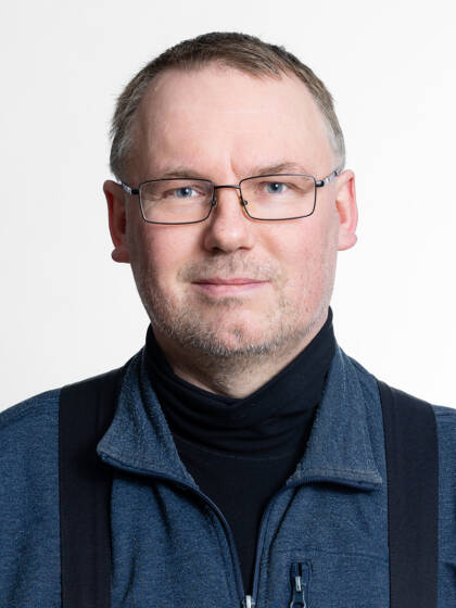 Henkilö jolla on lyhyet hiukset ja silmälasit.