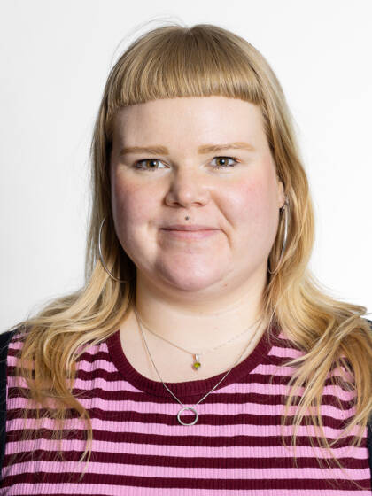 Close-up portrait of a person with long blonde hair and bangs.