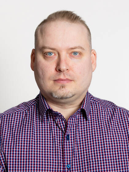 Kasvokuva henkilöstä jolla lyhyet hiukset ja ruutupaita.