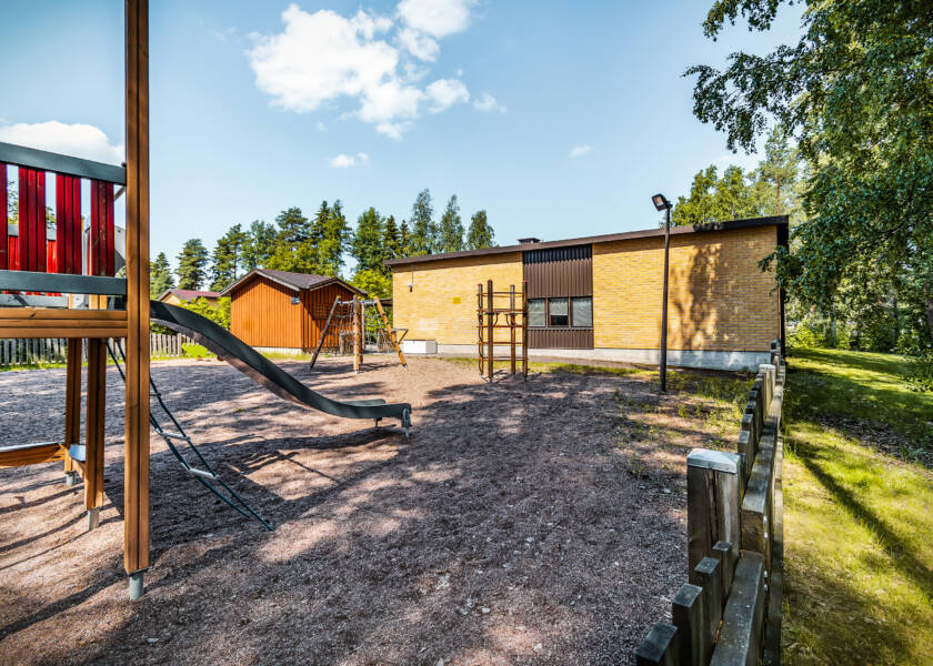 Leikkikenttä ja keltatiilinen rakennus