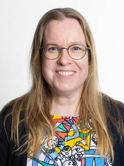 Kasvokuva henkilöstä jolla on pitkä vaalea tukka ja silmälasit.