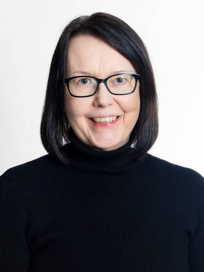 Close-up portrait of a person with a black bob haircut and black-framed glasses.