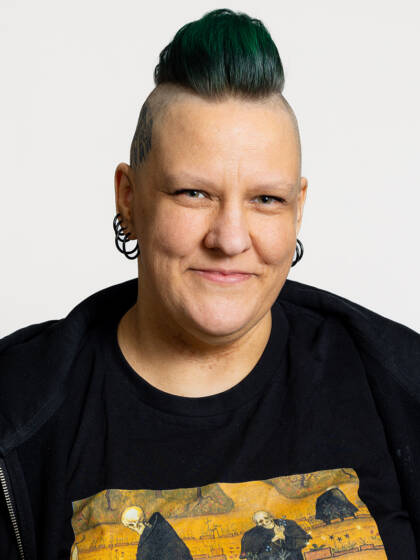 Kasvokuva henkilöstä jonka hiukset ovat sivuista siili ja päällä tummaa ja vihreää hiusta.