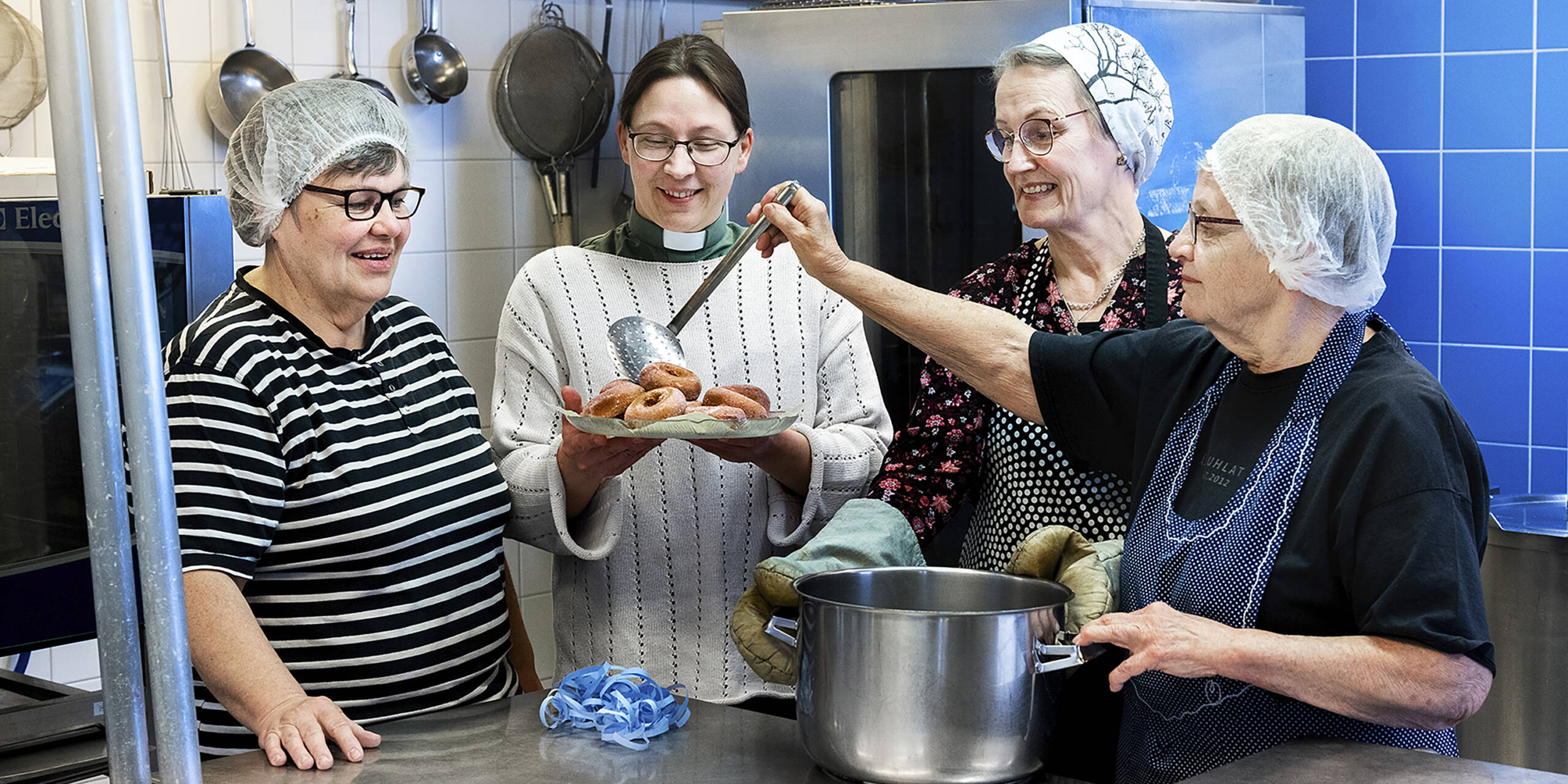 Henkilöitä valmistamassa vappumunkkeja Yhteisvastuukeräyksen ja lähetystyön hyväksi.