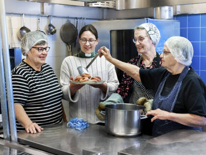 Henkilöitä valmistamassa vappumunkkeja Yhteisvastuukeräyksen ja lähetystyön hyväksi.