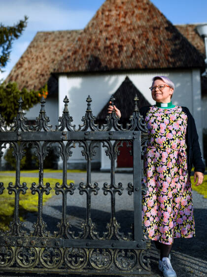 A person standing at the gate of the churchyard of Nurmo Church.