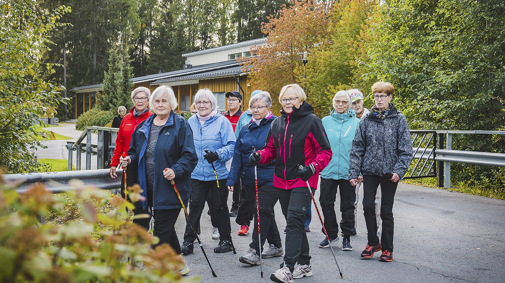 Ryhmä naisia ulkona syksyisessä maisemassa.