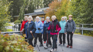 Ryhmä naisia ulkona syksyisessä maisemassa.