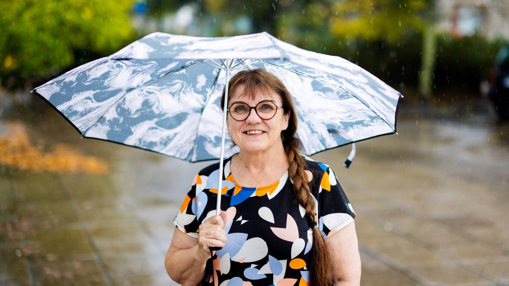 Ihminen ulkona sateenvarjo kädessä.