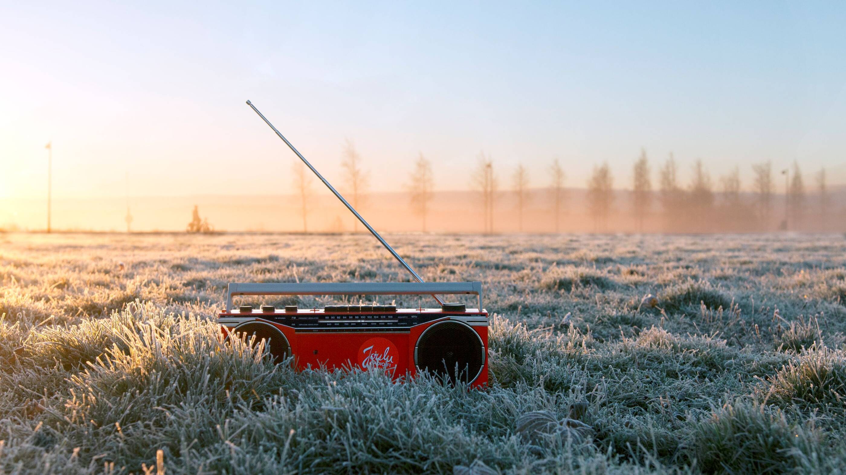 Punainen radio kohmeisessa maassa. Taustalla yksittäisiä puita.