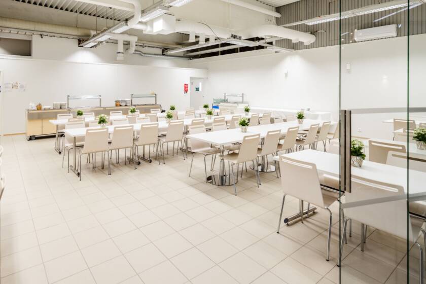 Dining room with tables and chairs. The room has white walls.